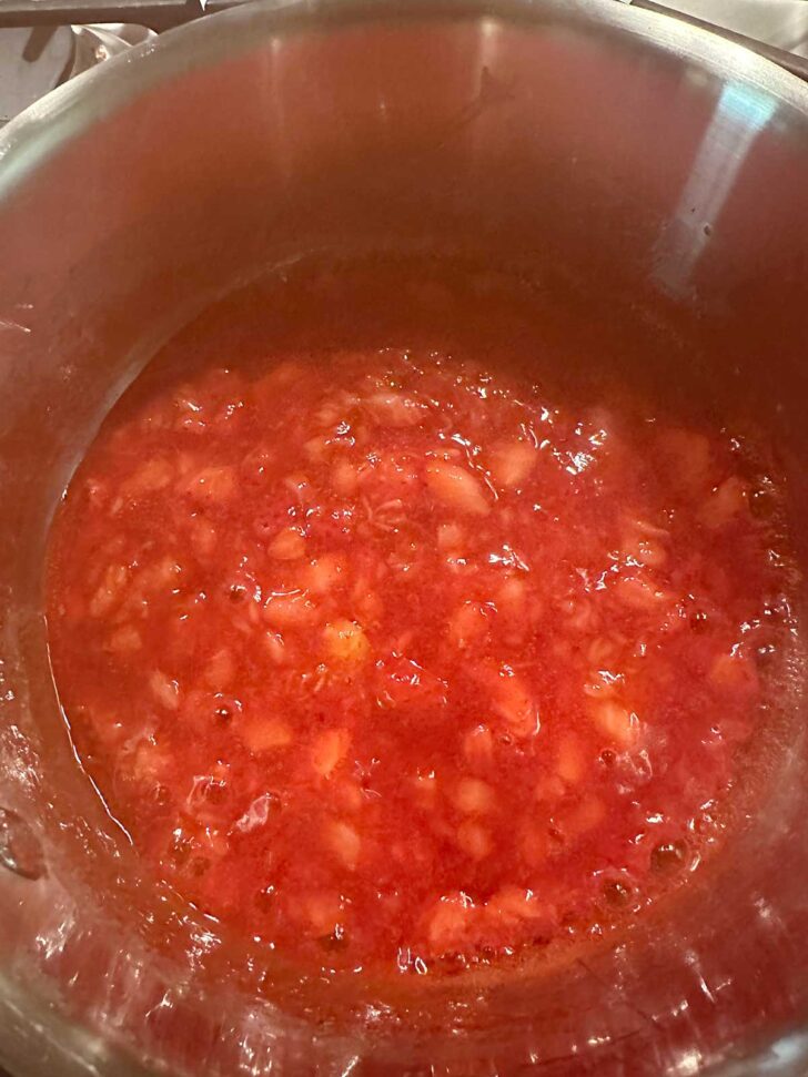 Strawberries simmering in saucepan.