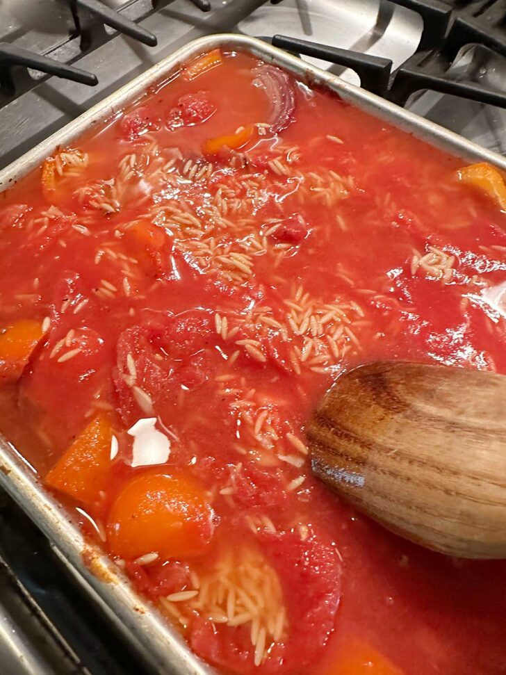 Stirring together the ingredients on the sheet pan.