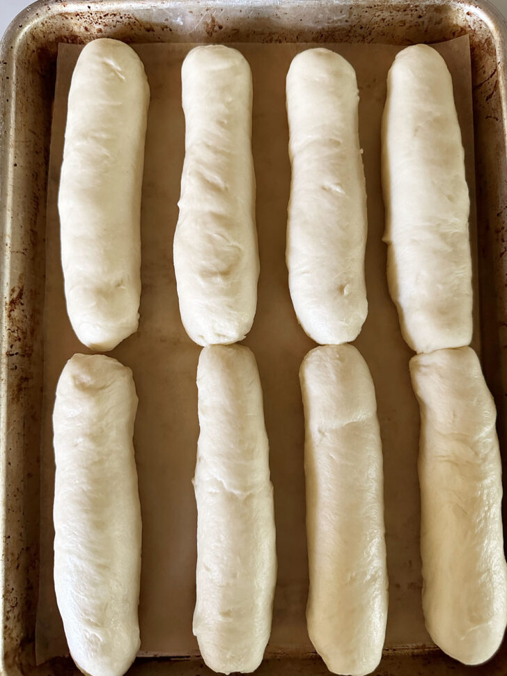 Rolled bun dough on baking sheet.