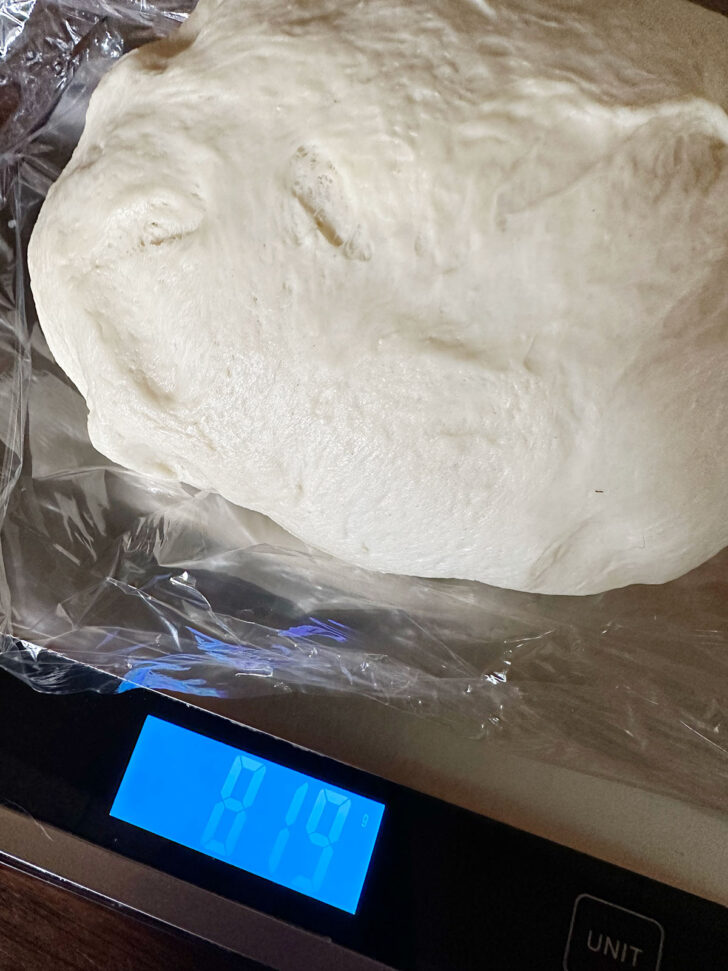 Weighing the dough ball on a scale.
