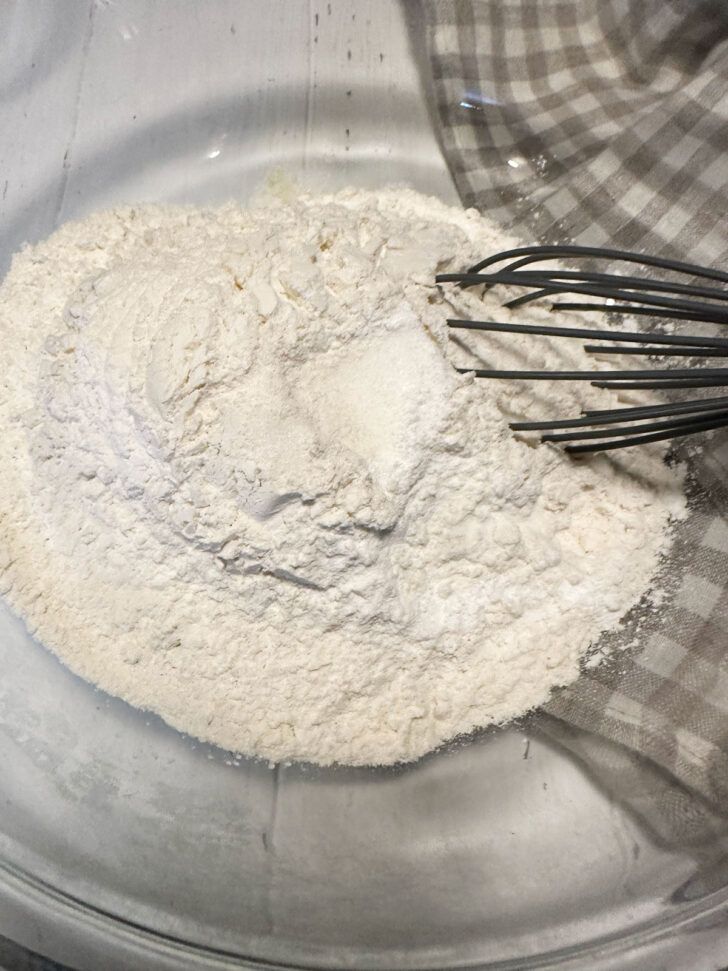 Dry ingredients in a bowl with a whisk.