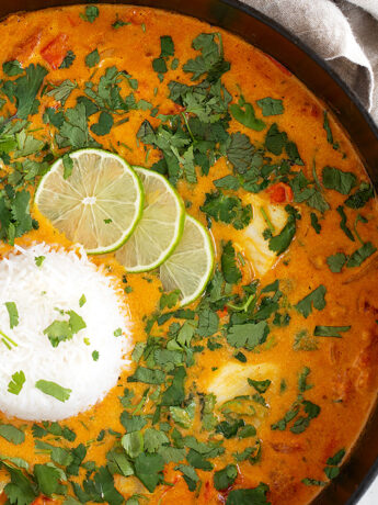 Coconut fish curry in skillet with rice.