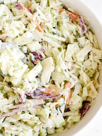 Coleslaw in bowl with spoon.