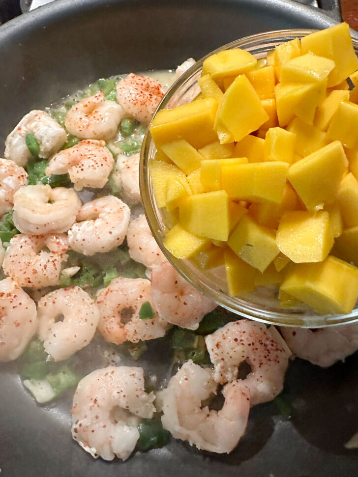Adding the mango to the skillet.