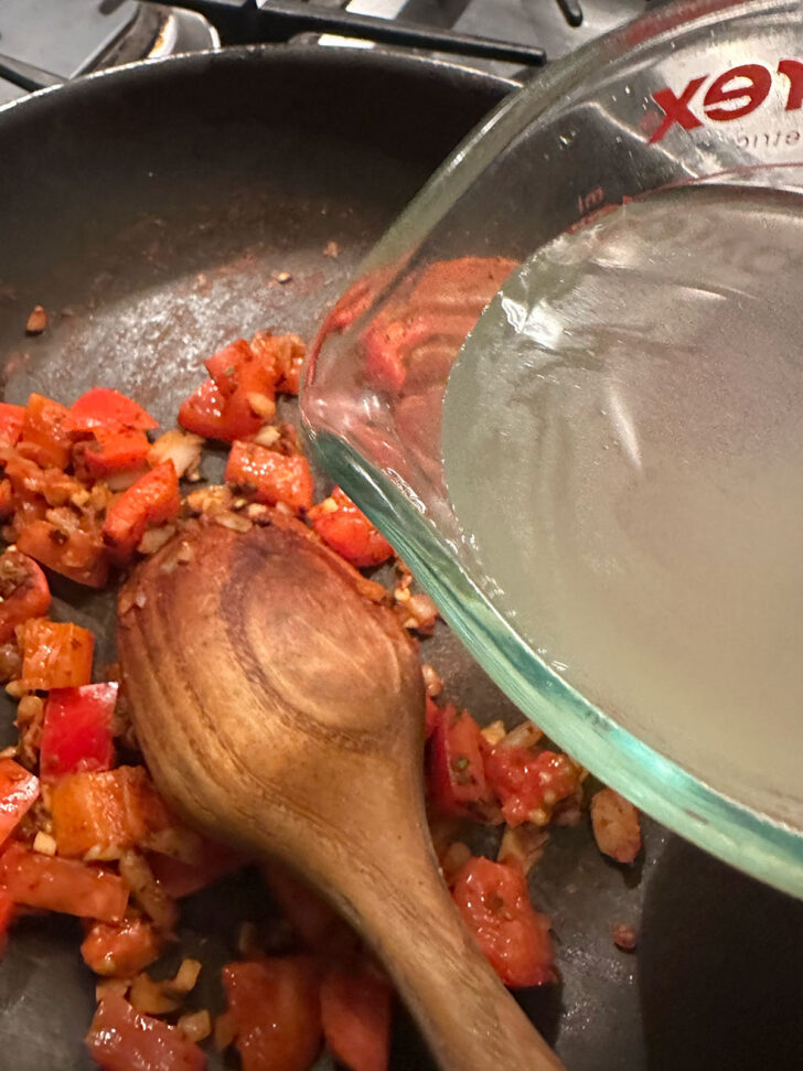 Add the chicken broth to the skillet.