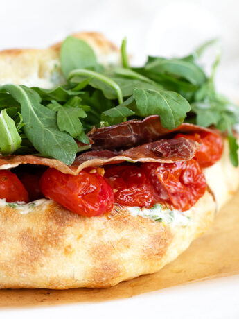 BLT pizza sandwich on parchment paper.