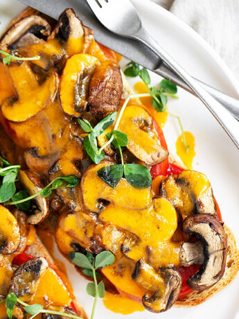 Cheese and tomato mushroom toast on plate.