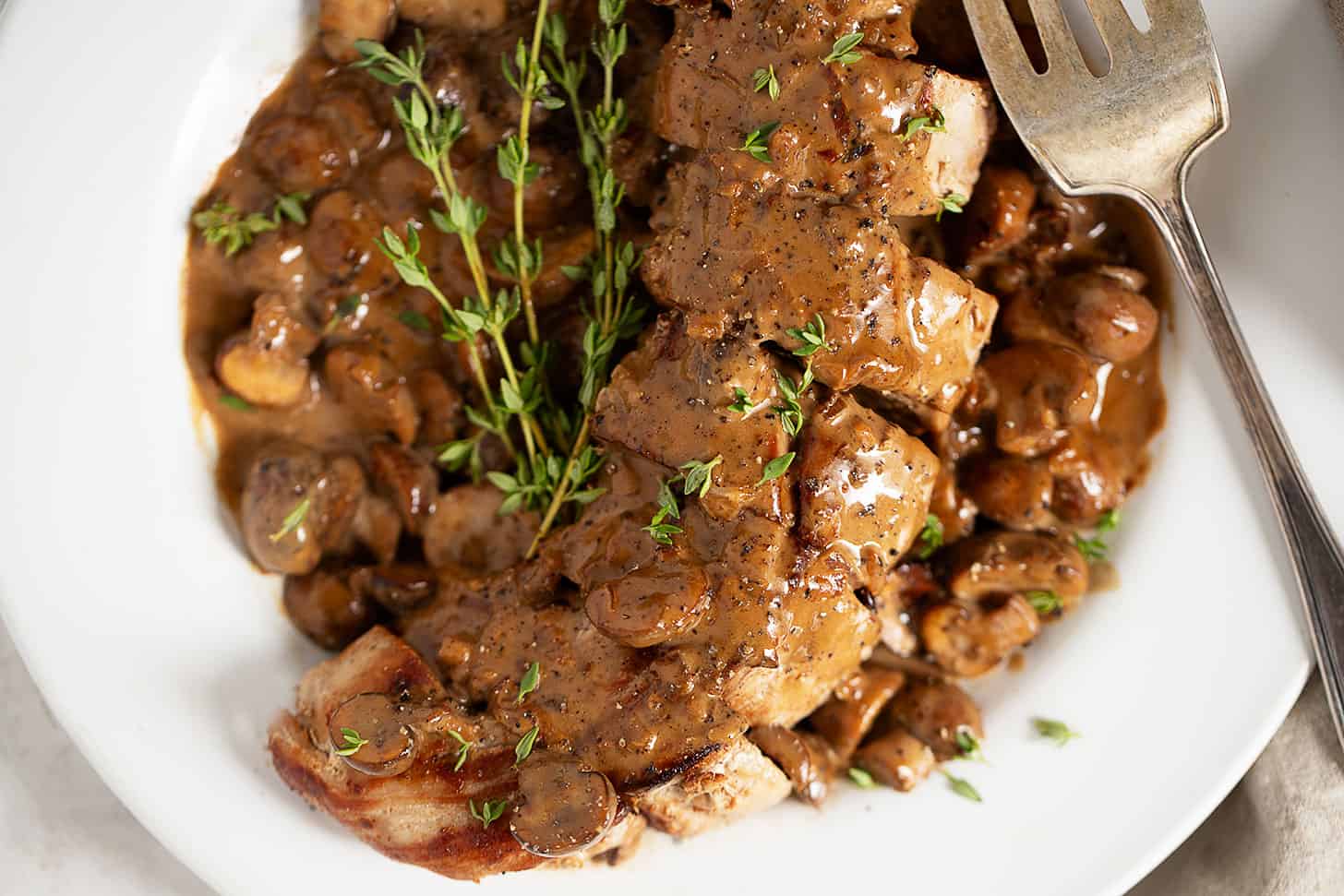 Pork diane on serving plate.