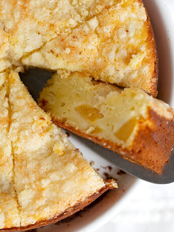 Peach cream cheese cake sliced on serving plate.