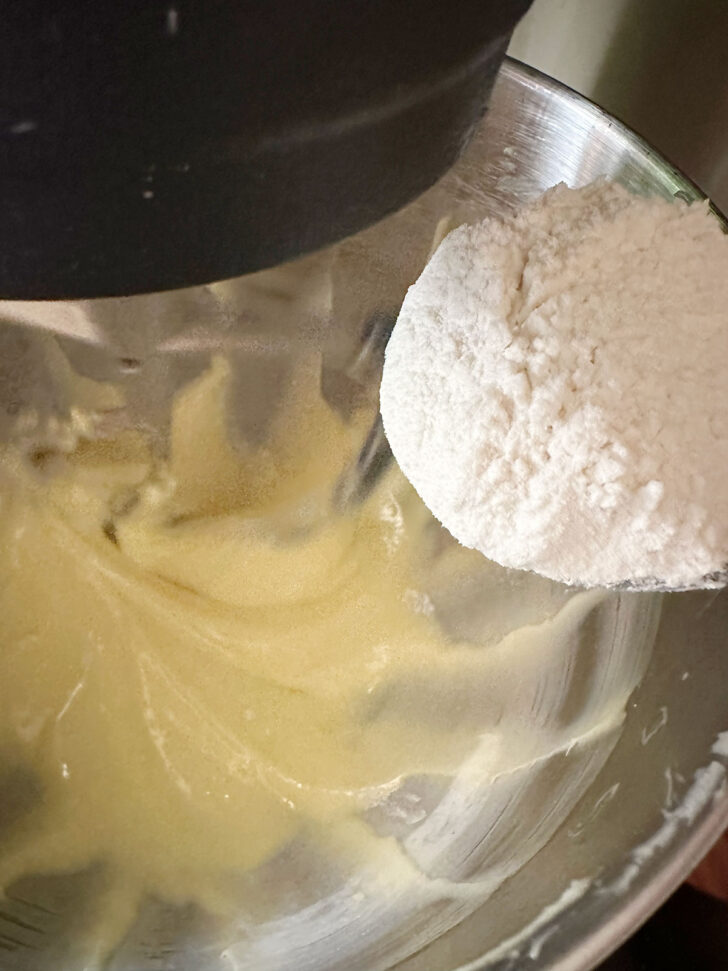 Adding flour mixture to the mixing bowl.
