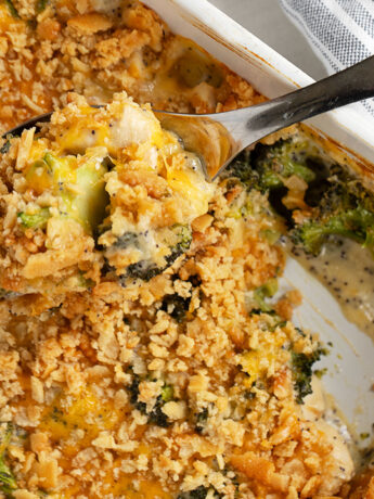 Poppy seed chicken casserole in baking dish with spoon.