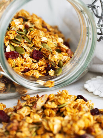 Pumpkin granola spilling out of jar.