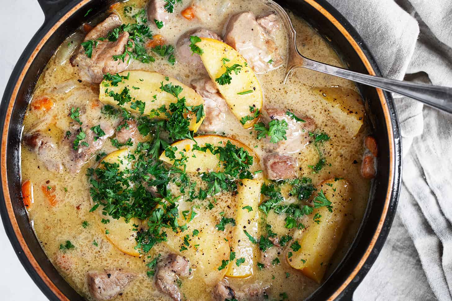 Braised pork with apples in baking dish.