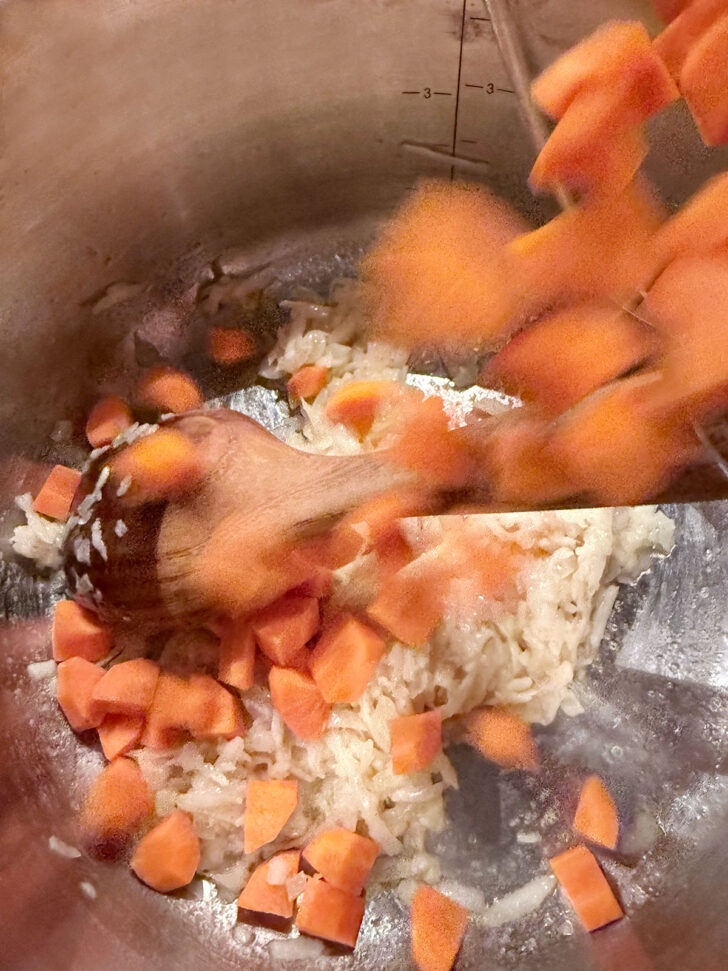 Adding the carrots to the pot.