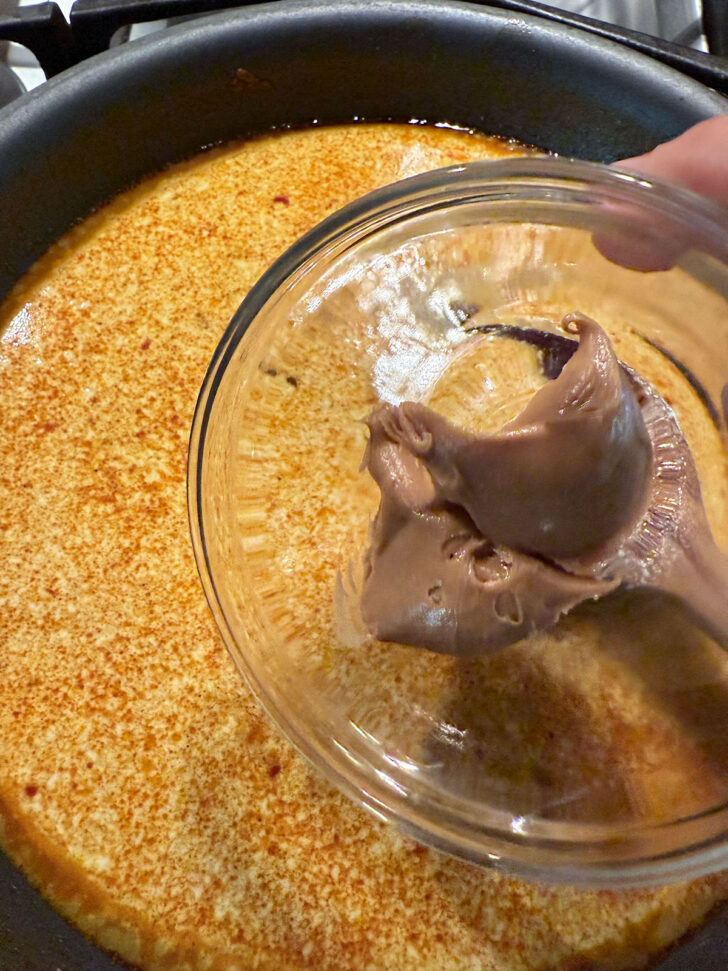 Adding peanut butter to the skillet.