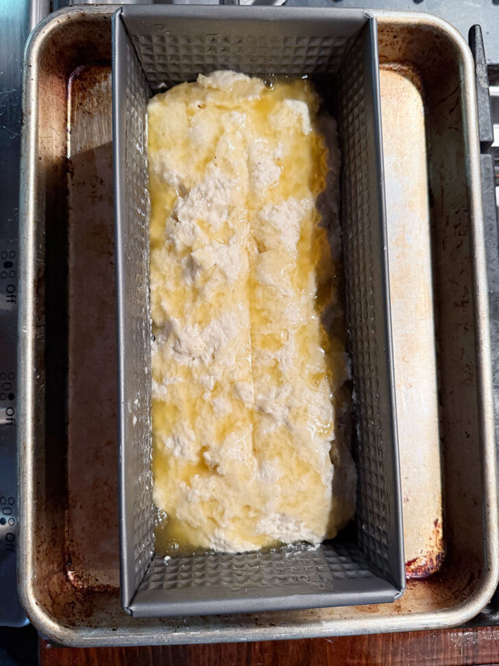 Loaf pan on top of a baking sheet before baking.