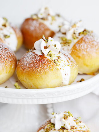 Pistachio maritozzi on a cake plate.