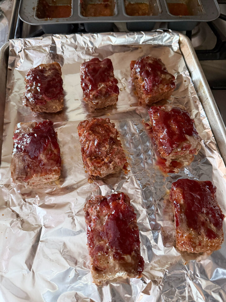 Mini meatloaves removed from the loaf pan and placed on a baking sheet.