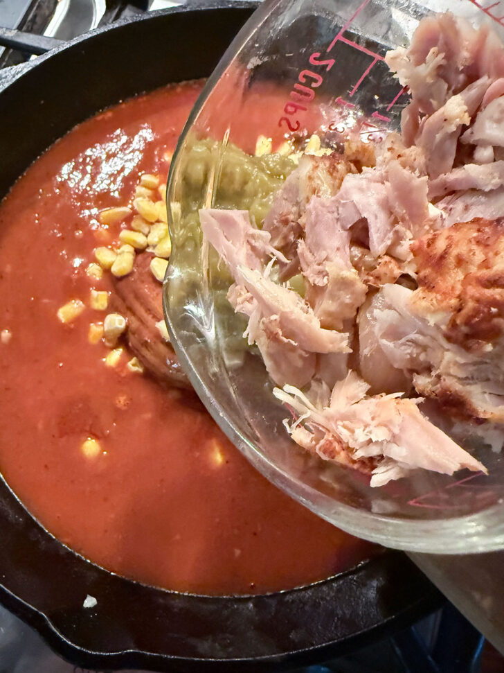Adding the cooked chicken to the skillet.
