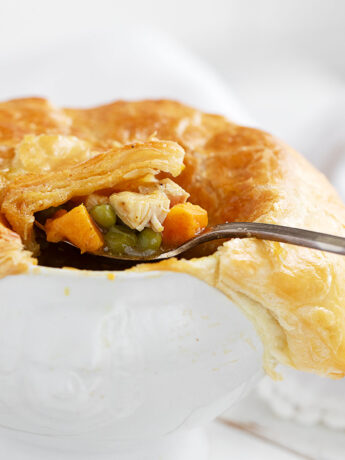 Curried chicken pot pie in baking dish with spoon.