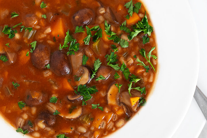 Mushroom barley soup in soup bowl.