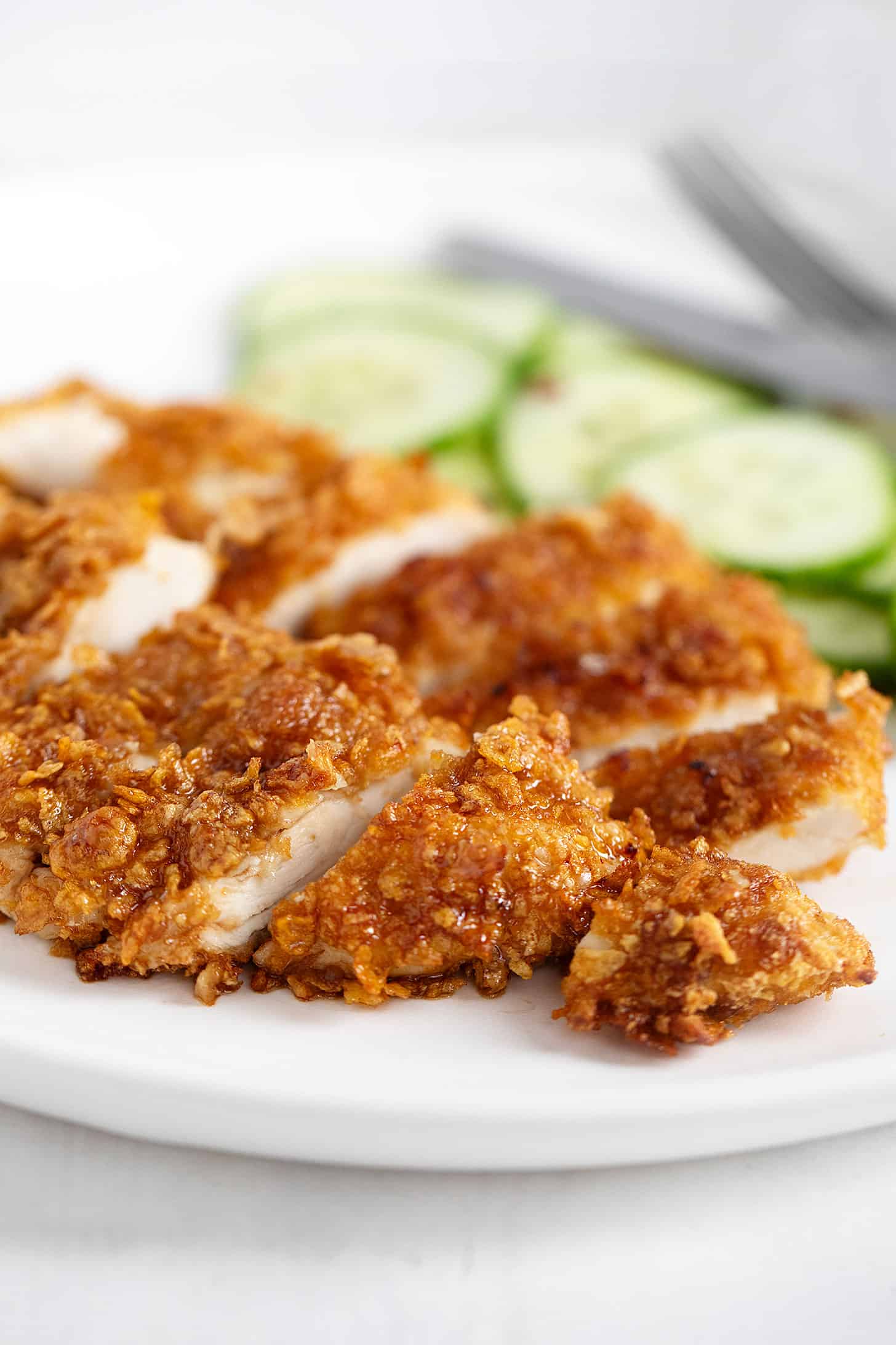 Cornflake chicken on plate with cucumbers.