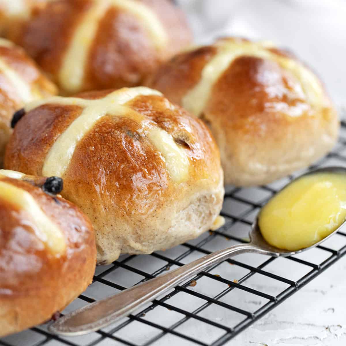 Lemon hot cross buns on cooling rack.