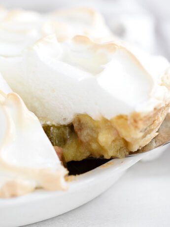 Rhubarb meringue pie sliced in pie dish.