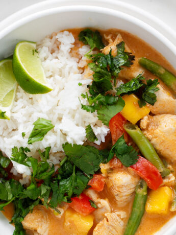 Thai mango chicken curry in bowl with rice.