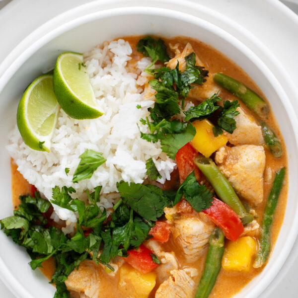 Thai mango chicken curry in bowl with rice.