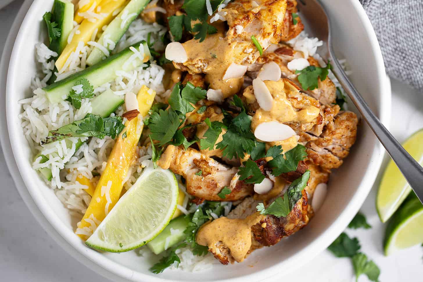 Coronation chicken rice bowl in bowl with fork.