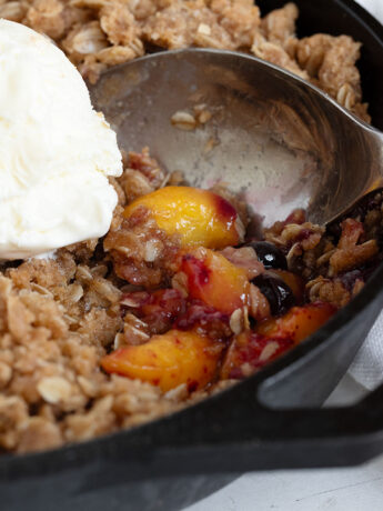 Peach blueberry crisp in a cast iron skillet.