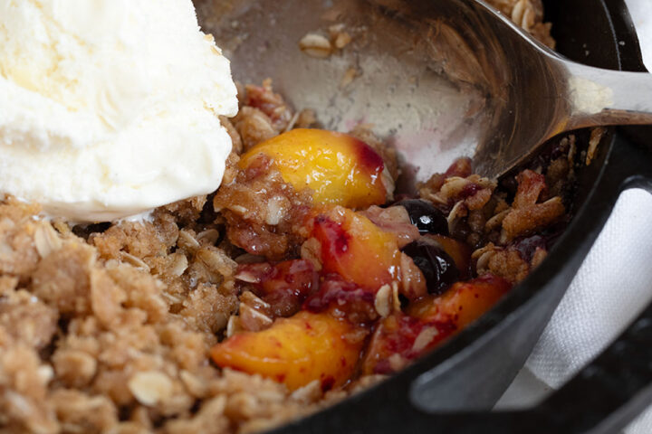 Peach blueberries are crispy in a cast iron skillet.