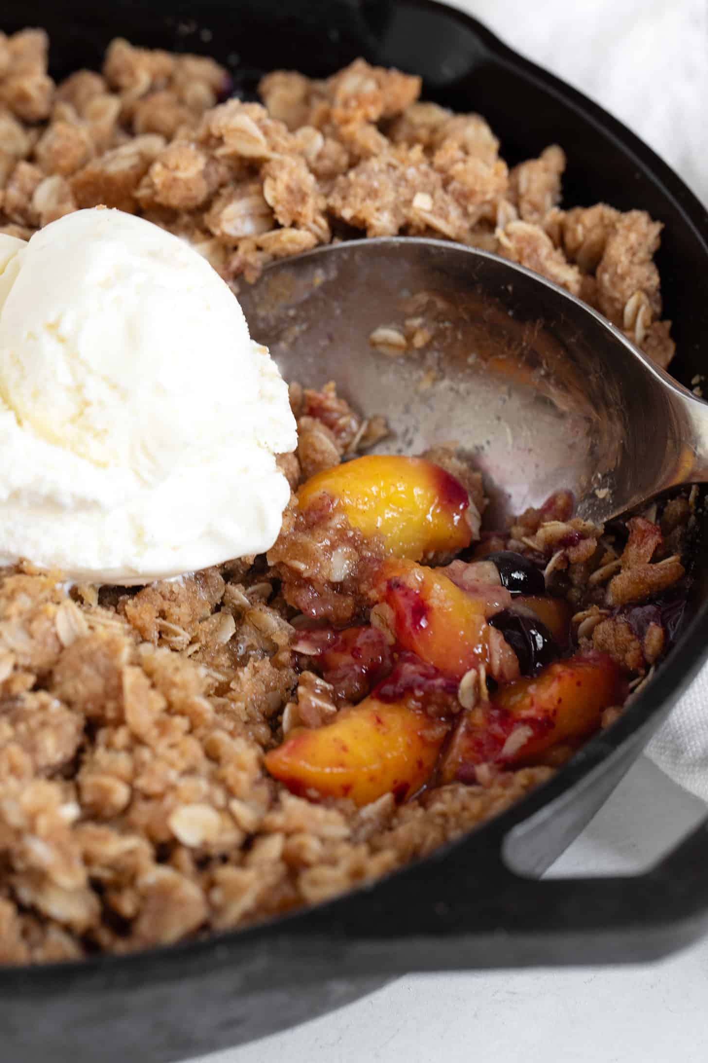 Peach blueberries are crispy in a cast iron skillet.