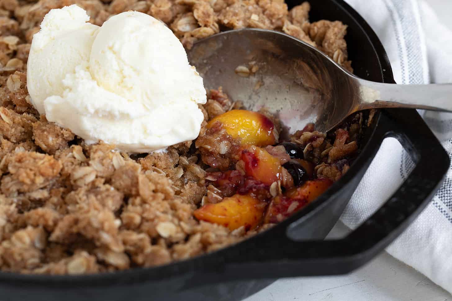 Peach blueberries are crispy in a cast iron skillet.