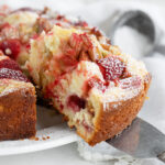 Strawberry rhubarb cake sliced on serving plate.