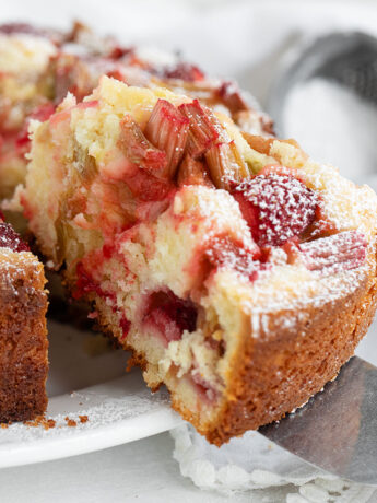 Strawberry rhubarb cake sliced on serving plate.