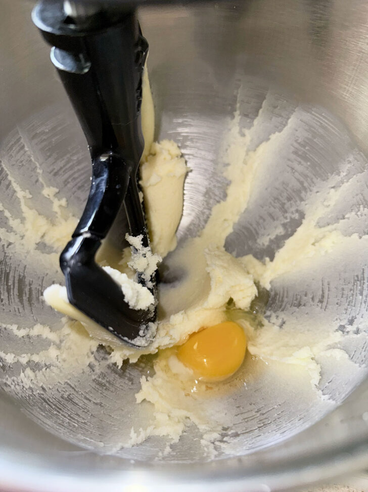 Adding egg to the creamed butter and sugar.