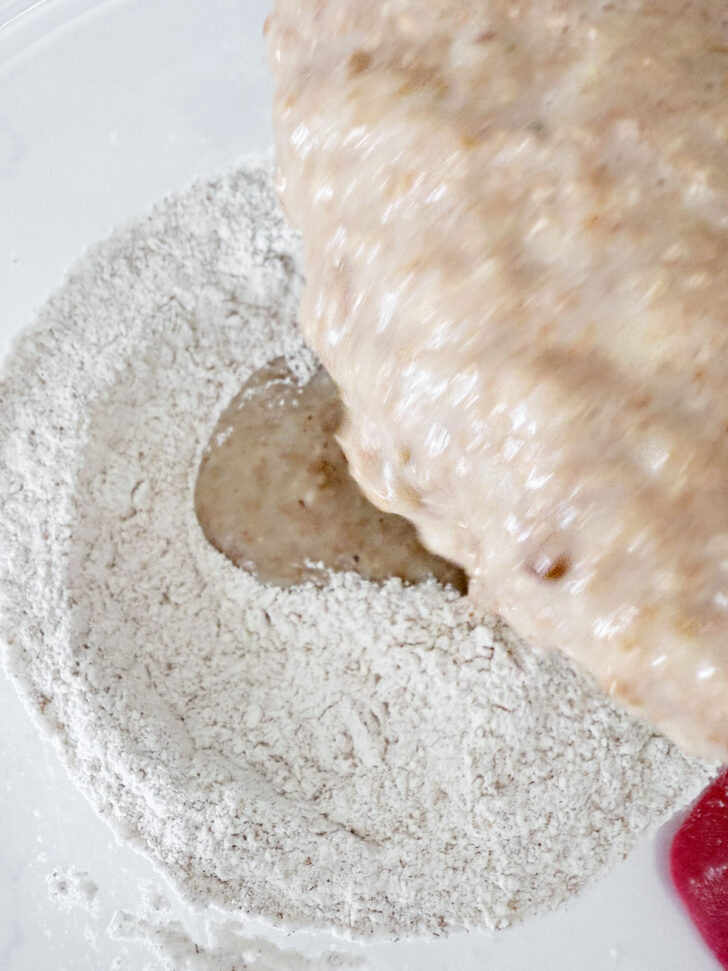 Adding the wet muffin ingredients to the dry muffin ingredients.