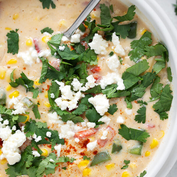 Creamy sweetcorn chowder in a bowl with a spoon.