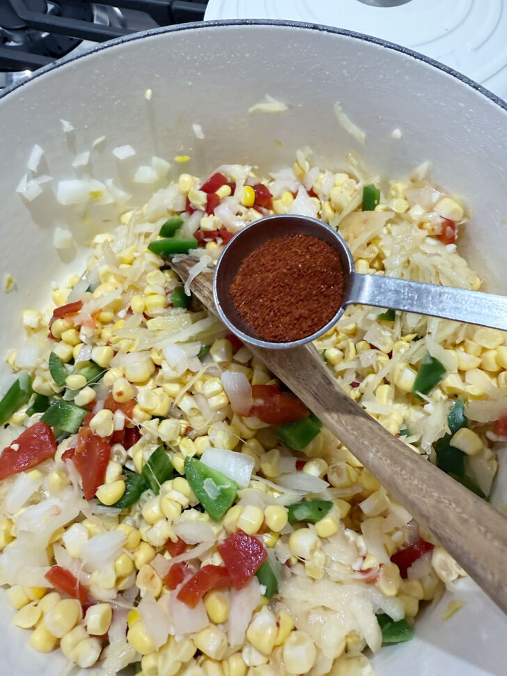 Adding chipotle chili powder to the pot.