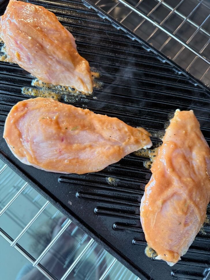 Sauce brushed on chicken on a grill pan.