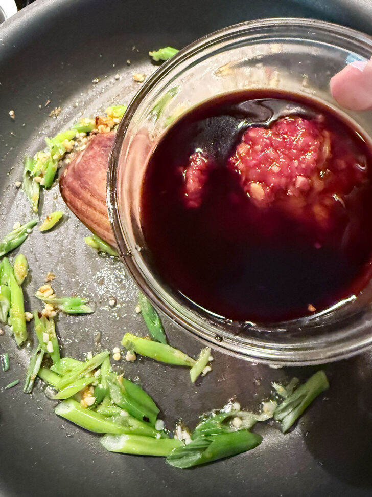 Adding the orange marmalade mixture to the skillet.