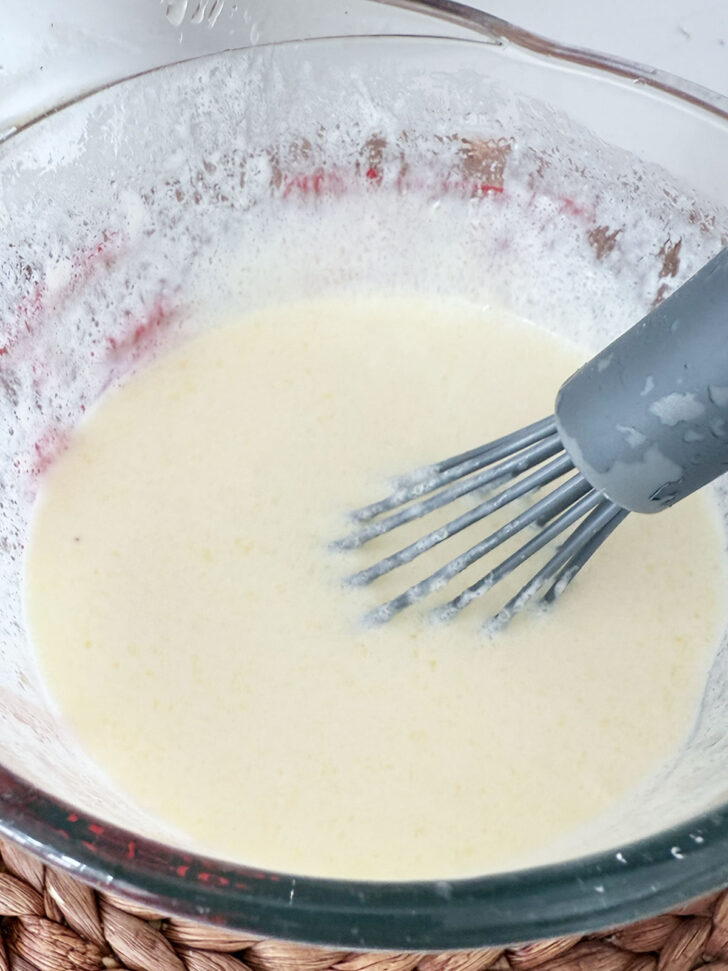 Mixing together the wet ingredients in a measuring cup.