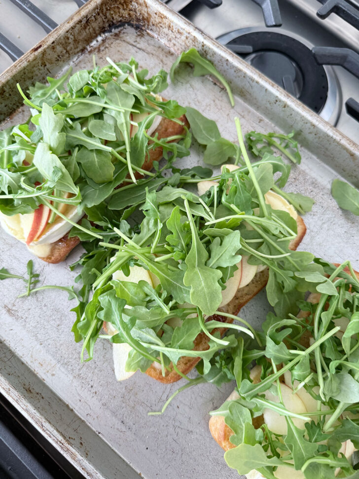Baby arugula placed on top of the apple slices.