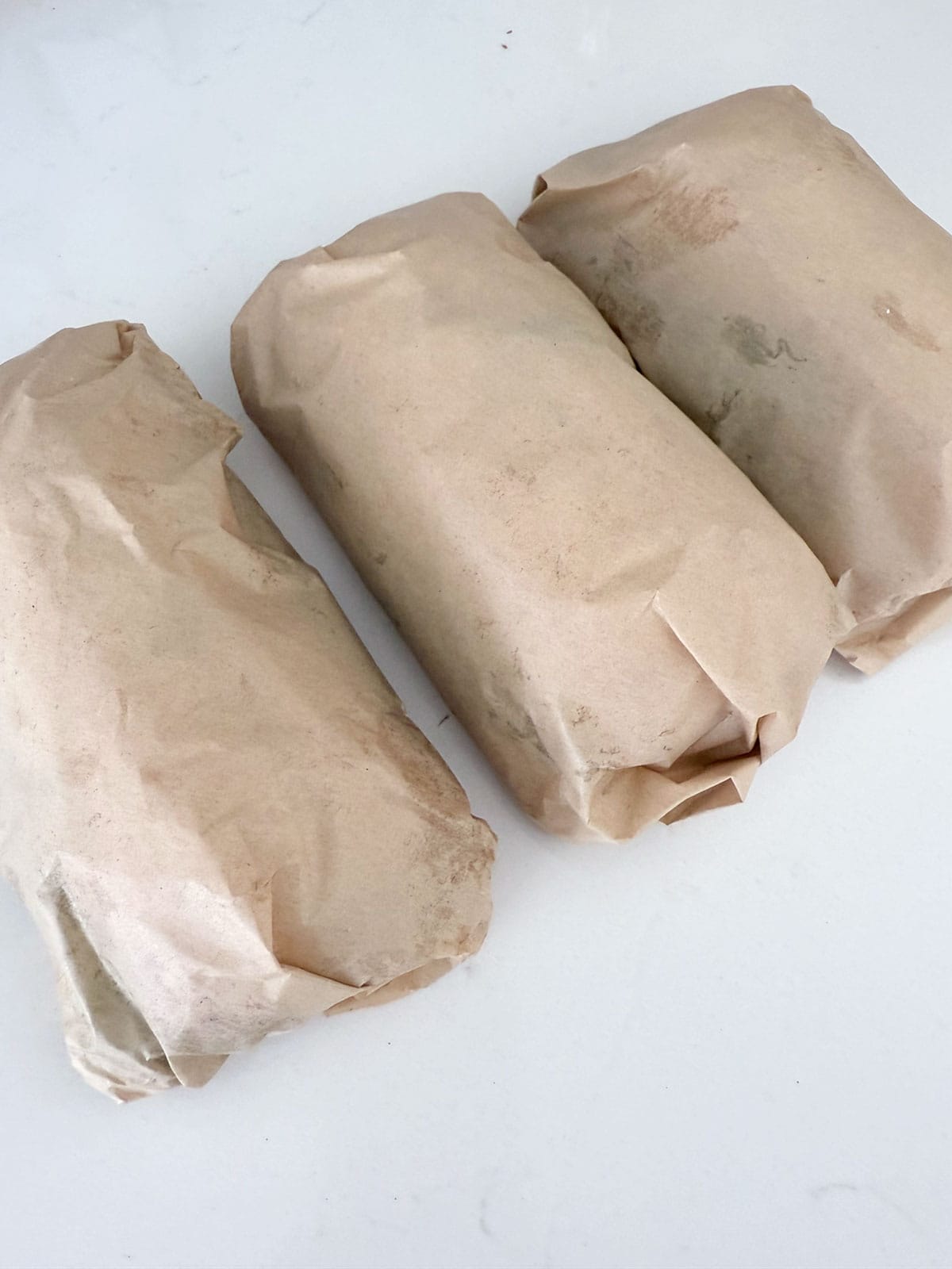 Apple Brie sandwiches wrapped in parchment paper.