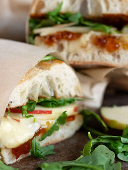 Apple Brie sandwiches wrapped in parchment and sliced.