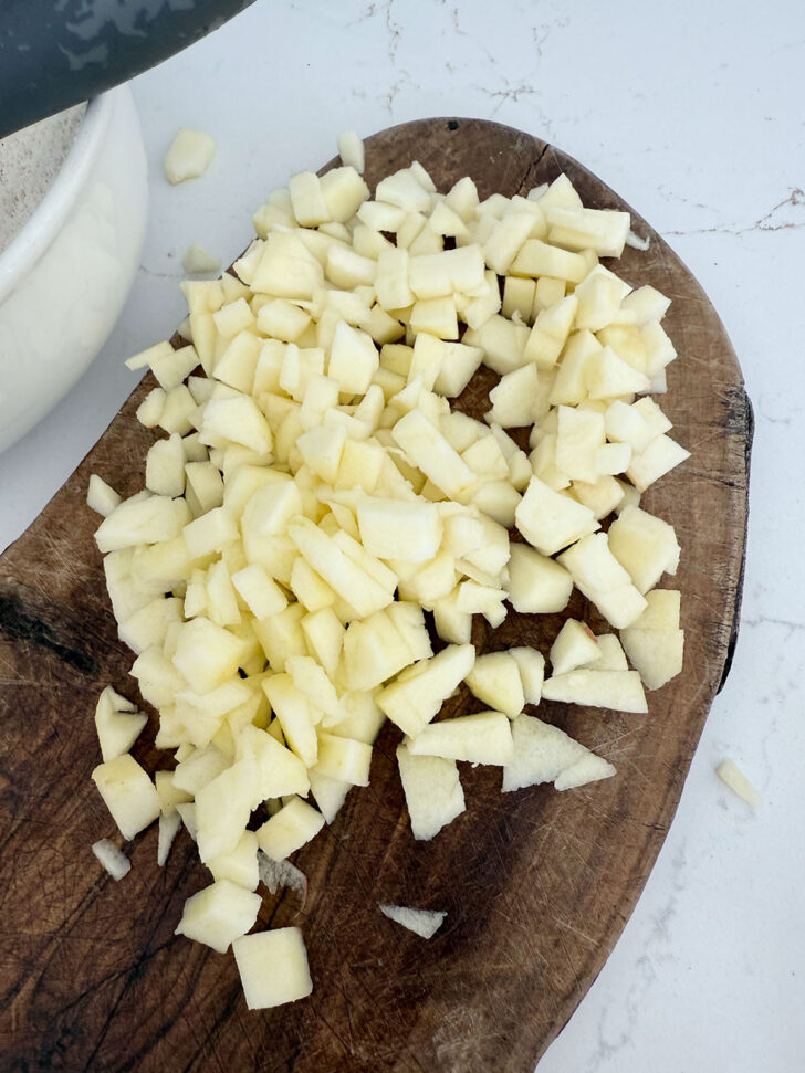 Apple peeled and diced on a cutting board.