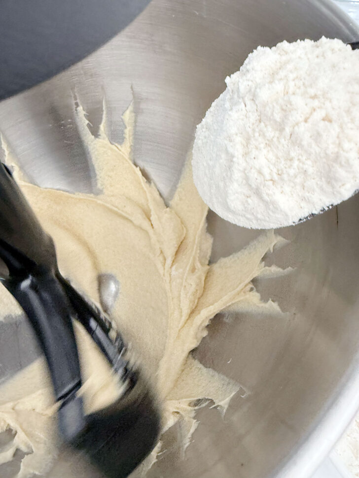 Adding the flour mixture to the muffin batter.