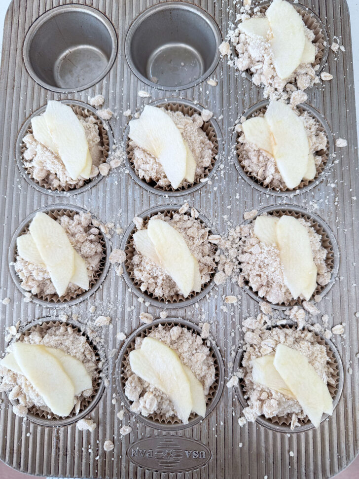Apple slices placed on top of the muffins before baking.